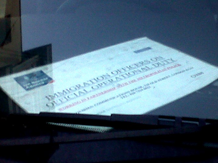 Sign left on the dashboard of one of the vans reads 'Immigration officers on official operational duty'